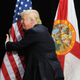 Donald Trump embracing the U.S. flag during a campaign rally on June 11, 2016, in Tampa, Fla.